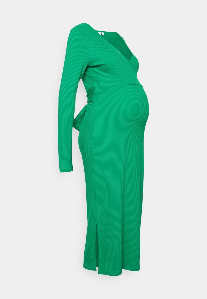 Robe de maternité verte côtelée avec manches longues, décolleté en V, liens latéraux et une longueur au genou avec des fentes sur les côtés pour une facilité de mouvement.