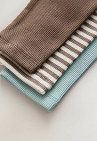 Drei Baumwoll-Leggings mit Rippstruktur: eine braun, eine gestreift in Braun und Creme, und eine hellblau; strukturierte Oberfläche, dehnbar, mit elastischen Bündchen.