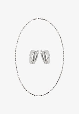 Collier en argent avec une chaîne à maillons, assorti à des boucles d'oreilles en argent présentant un design incurvé et une rangée de petites pierres claires.