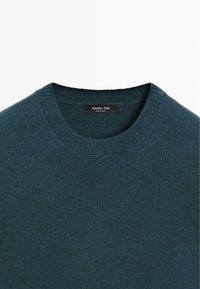 Tmavě tyrkysový pletený svetr s žebrovaným kulatým výstřihem. Uvnitř je textilní štítek, vyrobeno značkou Massimo Dutti. Měkká textura, minimalistický design.