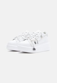 Białe sneakersy na platformie z gładką skórzaną powierzchnią, srebrnymi łańcuchowymi ozdobami oraz teksturowaną podeszwą zapewniającą przyczepność.