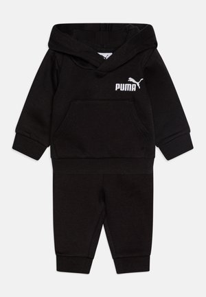 Čierny dvojdielny teplákový komplet vyrobený z mäkkej tkaniny. Obsahuje kapucňu, predné vrecko a biele logo Puma na vrchnej časti. Pružné manžety na nohaviciach.