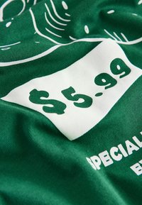 Zeleni materijal s dizajnom bijele oznake cijene, na kojoj piše "5,99 $" i "POSEBNO" u podebljanom, jasnom tisku, s glatkom teksturom.