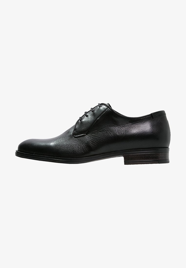 Chaussure Oxford formelle pour homme en cuir noir avec laçage fermé et talon bas empilé, vue de profil sur fond blanc.