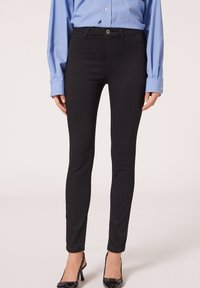 Pantalones vaqueros negros ajustados, hechos de denim, con un diseño ceñido, estilo clásico de cinco bolsillos y un simple cierre de botón en la cintura.