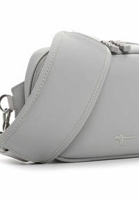 Helehall, ristkülikukujuline kott, mis on valmistatud siledast materjalist ja millel on tõmbluku sulgur ning eemaldatav rihm. Peen õmblus ja logo detailid.