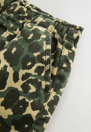 Camo-mønstrede shorts med et grønt og beige design, der har en elastisk talje og en sidelomme. Tekstureret bomuldsstof.