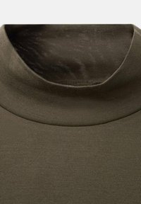 Olivgrüner Rollkragenpullover aus weichem, dehnbarem Stoff. Verfügt über eine glatte Textur und ein eng anliegendes Design mit hohem Kragen.