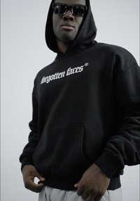 Black hoodie with front pocket and white "forgotten faces" logo. Smooth fabric, relaxed fit, and drawstring hood.