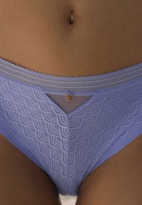 Lavender čipkast modrček z valovitim pasom, geometrijski vzorec, pol prosojna mrežasta panel in majhen okrogel zlati detajl.