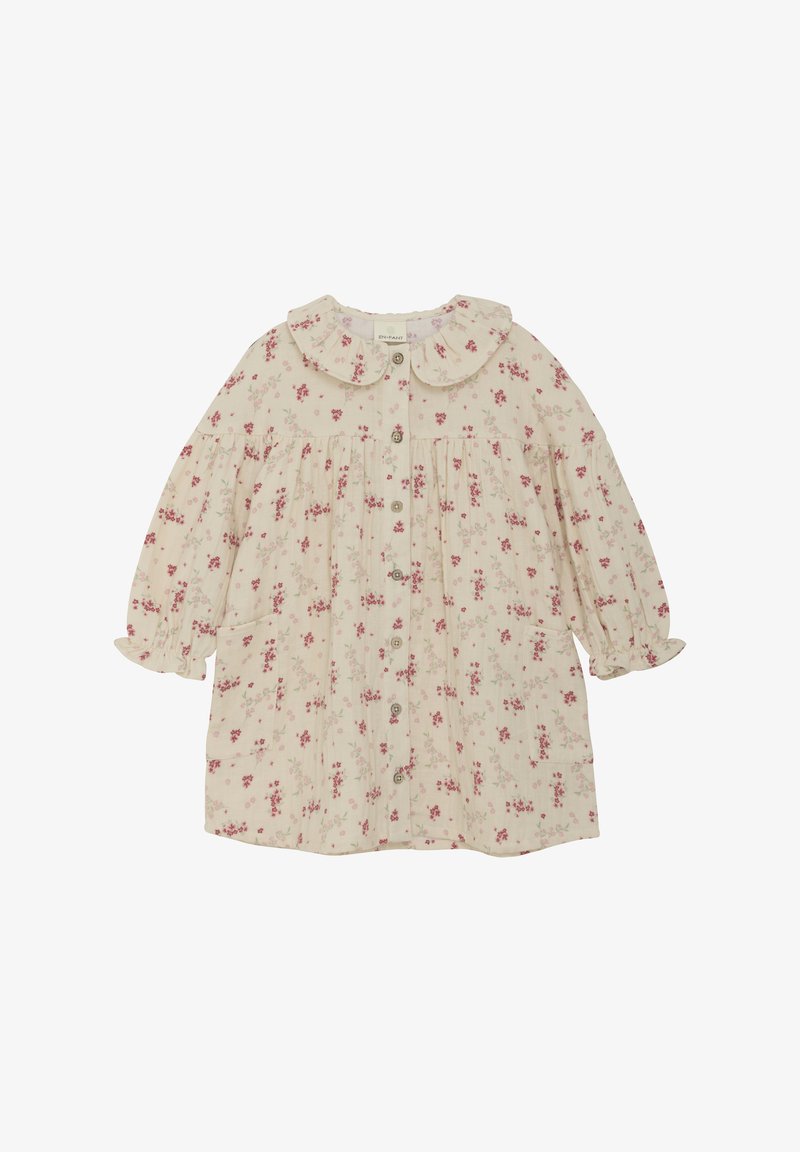 Sukienka w kwiatowy wzór w jasnym beżu z różowymi kwiatami. Posiada okrągły kołnierzyk, bufiaste rękawy, zapięcie na guziki oraz dwie boczne kieszenie.