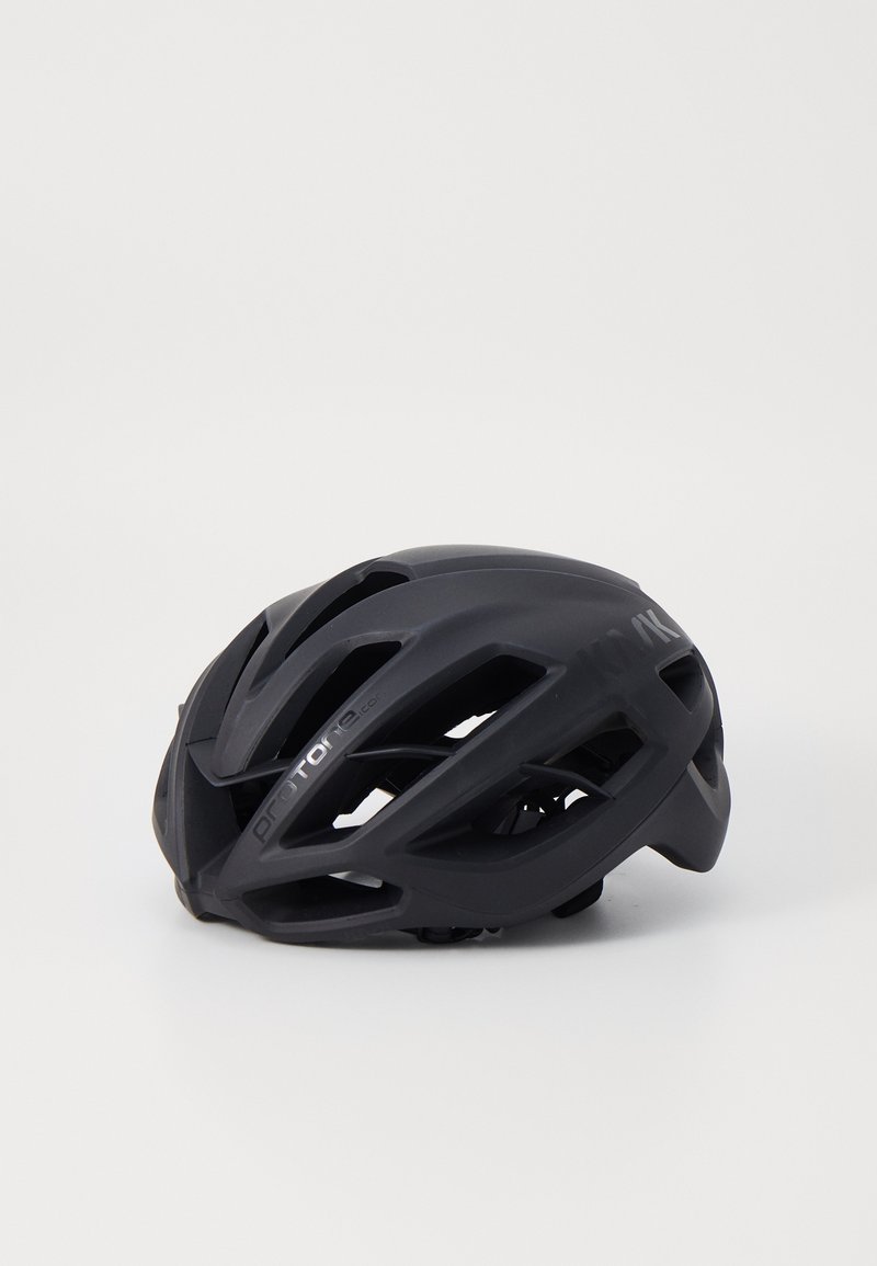 Casque de cyclisme noir au design aérodynamique, avec plusieurs fentes de ventilation, finition mate et accent logo argenté. Construction élégante et légère.