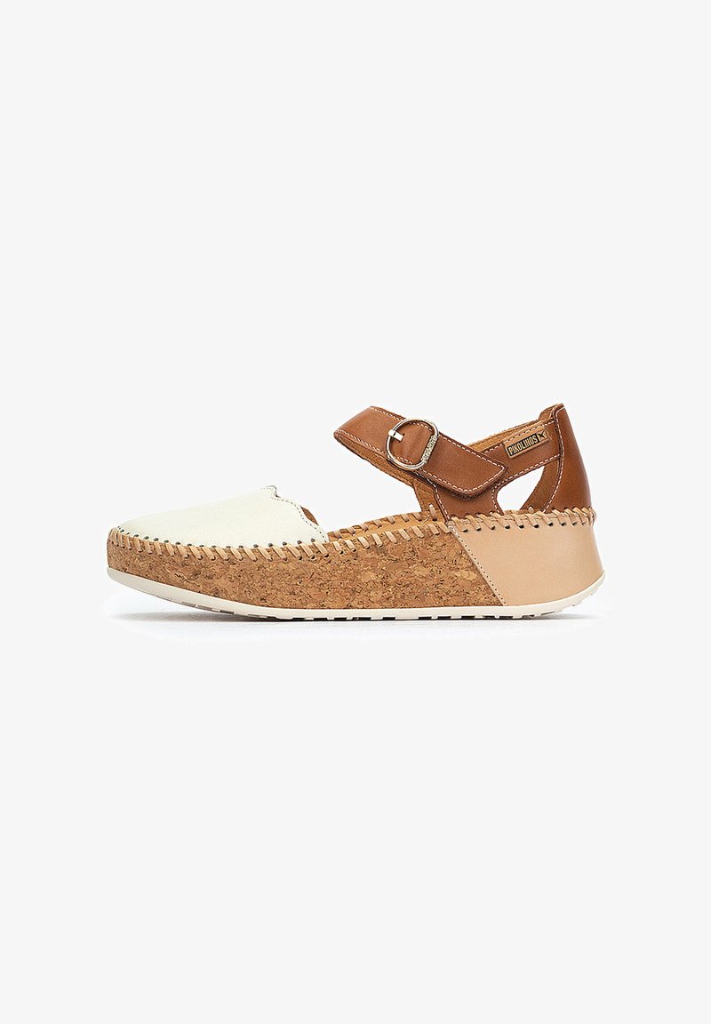 Chaussure en cuir marron et toile blanche avec semelle en liège, bride réglable avec boucle, et accents cousus le long du bord supérieur.