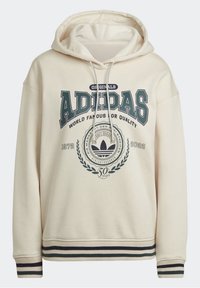 Felpa crema Adidas con stampa frontale che recita "Originals Adidas World Famous for Quality 1972-2022", con orlo e polsini a righe.