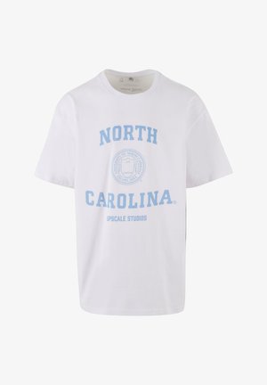 Witte katoenen t-shirt met lichtblauwe tekst, "NORTH CAROLINA" en "UPSCALE STUDIOS," met een cirkelvormig embleemontwerp in het midden.