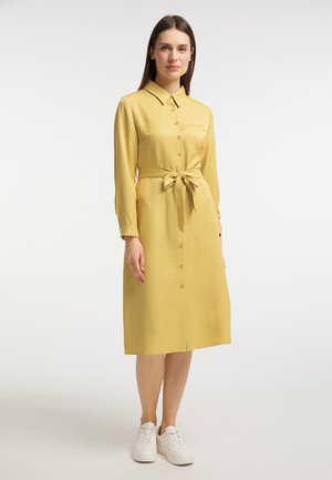 Abito giallo a maniche lunghe con colletto da camicia, chiusura con bottoni e dettaglio della cinturina annodata in vita. Tessuto morbido, design lungo fino al ginocchio.