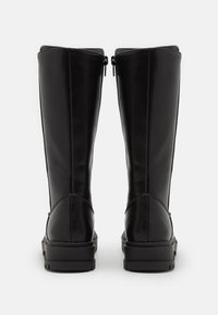 Bottes en cuir noir montant jusqu'aux genoux avec une texture lisse, dotées d'un bout arrondi et de deux fermetures éclair latérales. Semelles épaisses en caoutchouc durable.