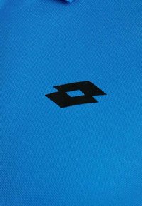 Polo bleu avec un tissu texturé et un logo noir bien visible. Le design comprend un col classique et des lignes épurées.