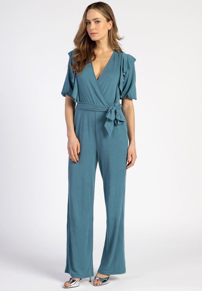 Teal wikkel jumpsuit met korte gerimpelde mouwen, een strik taille en wijde pijpen. Gladde textuur met een diepe V-hals.