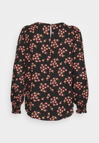 Blusa nera con maniche a sbuffo che presenta un motivo floreale di fiori rosa. Include un dettaglio a chiave sul retro. Tessuto leggero.