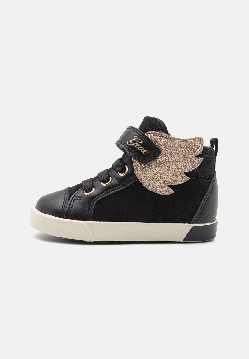 Baskets montantes noires avec détail d’aile en paillettes dorées, lacets noirs, bande velcro et semelle beige, conçues pour enfants.