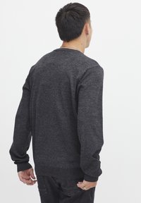 Dunkelgrauer Sweatshirt mit Rundhalsausschnitt und langen Ärmeln. Der Stoff wirkt weich und texturiert und hat gerippte Bündchen und einen gerippten Saum.