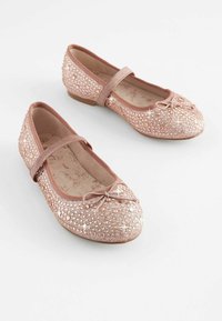 Bailarinas rosas con punta redonda, decoradas con cristales y un pequeño lazo en la parte delantera. Material suave con una correa elástica.