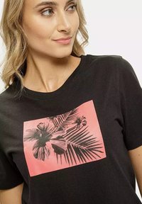 Czarny t-shirt z prostokątnym, różowym nadrukiem kwiatowym z szkicami liści i kwiatów, ozdobiony srebrnymi ćwiekami na krawędziach.