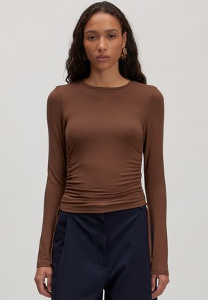 Bruine lange mouwen top met een ronde hals, geplooide zijdetails en een getailleerde silhouet. Gemaakt van een gladde, rekbare stof.