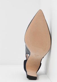 Chaussure féminine noire à bout pointu avec une semelle texturée, une pointe de talon visible et une inscription de taille 37 sur la semelle extérieure beige.