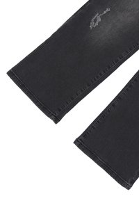 Jeans in denim nero con un design a gamba dritta, caratterizzati da dettagli strappati sulla coscia sinistra e cuciture ordinate lungo gli orli.