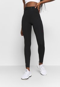 Zwart high-waisted leggings van rekbaar materiaal, met een logo-opdruk aan de tailleband, een gladde textuur en reflecterende accenten langs de zijkant.