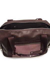 Lederhandtasche mit einer strukturierten burgunderfarbenen Oberseite, ausgestattet mit einem Reißverschluss und einem kontrastierenden pinken gemusterten Boden. Enthält eine Fronttasche.