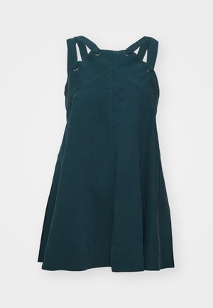 Robe sans manches de couleur bleu-vert avec un corsage ajusté et une jupe évasée. Présente des coutures diagonales, des bretelles ajustables avec des accents en métal, et des poches latérales.