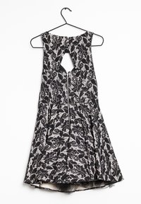 Black lace dress with floral pattern, sleeveless design, keyhole back, and zipper closure at the waist, hanging on a black hook.