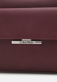 Calvin Klein LINEAR CAMERA BAG - Bandolera - oxblood