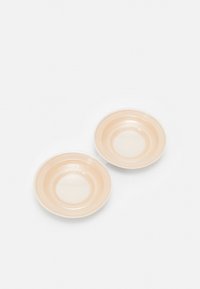 Two round, shallow dishes in a soft peach color with a smooth, glossy finish and subtle concentric circle patterns.