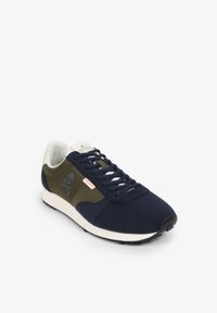 Marineblauwe en olijfgroene sneaker gemaakt van mesh en suede, met een doodshoofdlogo, witte zool en zwarte rubberen loopzool. Ronde neus en vetersysteem.