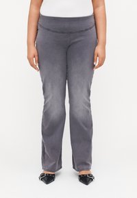 Gray, stretchy pants with a high waist and a smooth texture. Features a slim fit through the thighs, flaring slightly at the ankles.