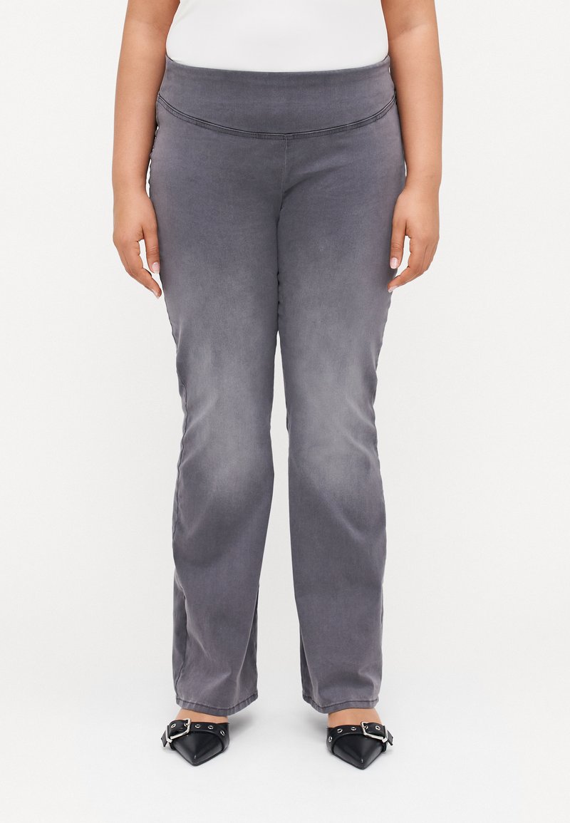 Gray, stretchy pants with a high waist and a smooth texture. Features a slim fit through the thighs, flaring slightly at the ankles.