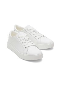 Baskets en cuir blanc avec une texture lisse, bout rond, semelle en caoutchouc plate et un design classique à lacets. Détails de couture subtils.