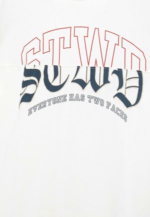 Tricou alb cu text grafic îndrăzneț. Textul de sus, scris cu litere roșii, spune "STWD," iar textul de jos, în albastru marin, afirmă "Fiecare are două fețe." Material moale.