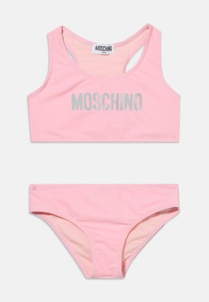 Ροζ σετ μαγιό δύο τεμαχίων με το λογότυπο MOSCHINO στο τοπ τύπου αθλητικού σουτιέν, σχεδιασμένο για εφήβους, σε λευκό φόντο.
