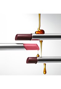 Deux rouges à lèvres, l'un rose et l'autre d'un bourgogne profond, sur des tubes métalliques à finition brillante, des gouttes de liquide doré dévalant.