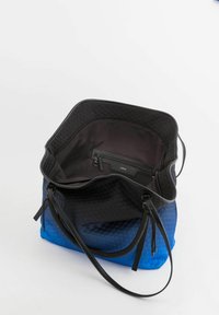 Torebka na ramię w sześciokątny wzór przechodząca od czerni do niebieskiego. Wnętrze posiada czarną kieszeń. Dwa czarne uchwyty. Gładka tekstura.