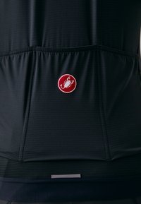 Jersey tecnico da ciclismo nero con tessuto testurizzato, caratterizzato da un logo circolare rosso con uno scorpione bianco. Include una tasca posteriore per la conservazione.