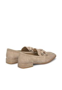 Beige Wildleder Loafers mit flachem Absatz, spitzer Zehe und dekorativen, geschlungenen Riemen mit metallic Akzenten. Glatte Textur und einfaches Design.