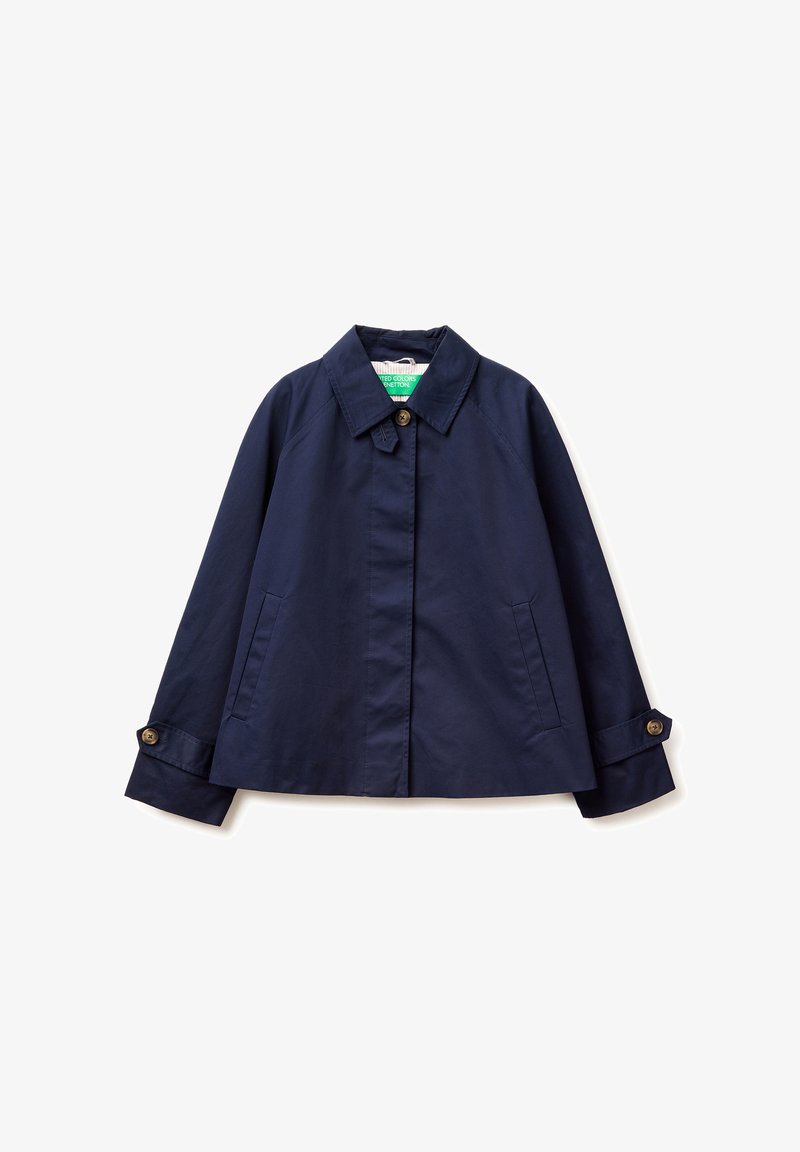 Veste légère bleu marine avec col pointu, poignets boutonnés, poches latérales et boutons avant cachés, étalée à plat sur un fond blanc.