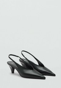 Slingback con tacco kitten in pelle nera, con punte appuntite e tacco curvo basso su uno sfondo neutro.