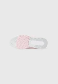 Semelle de chaussure de sport rose et blanche avec une surface en caoutchouc texturée présentant un motif en zigzag et un arc pour le soutien.